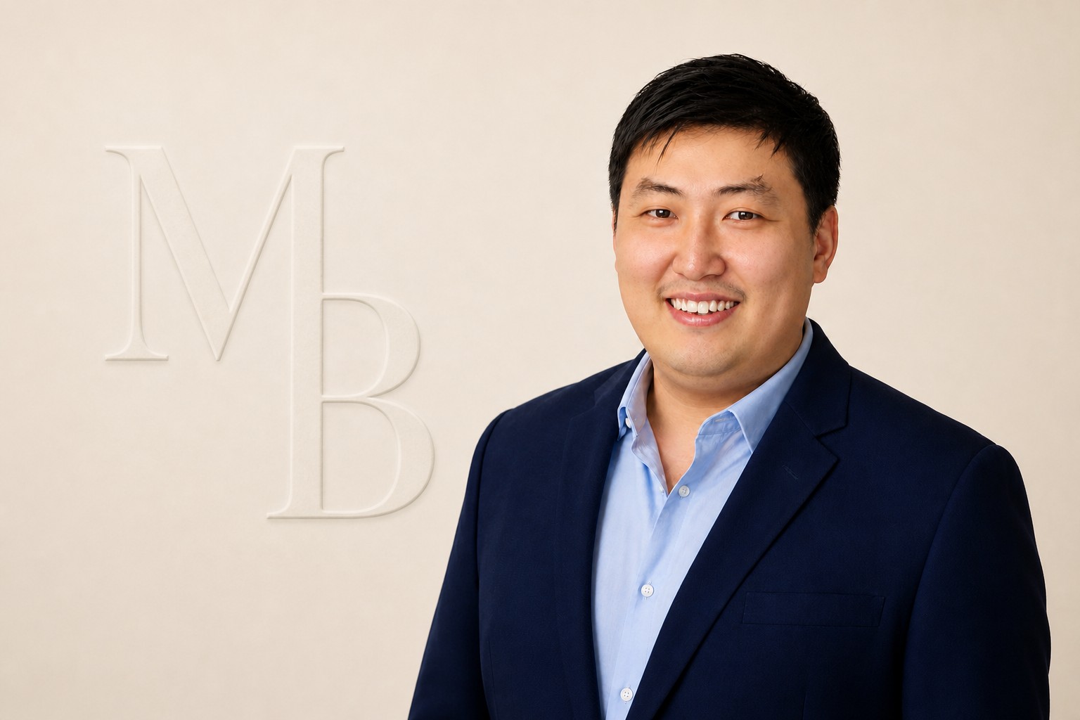 Portrait of Lee Mun Boon against a warm ivory background embossed with the initials MB